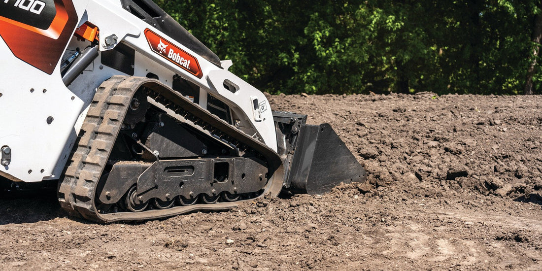 Screened topsoil being graded with a track loader, one of the materials compared for lawn topdressing