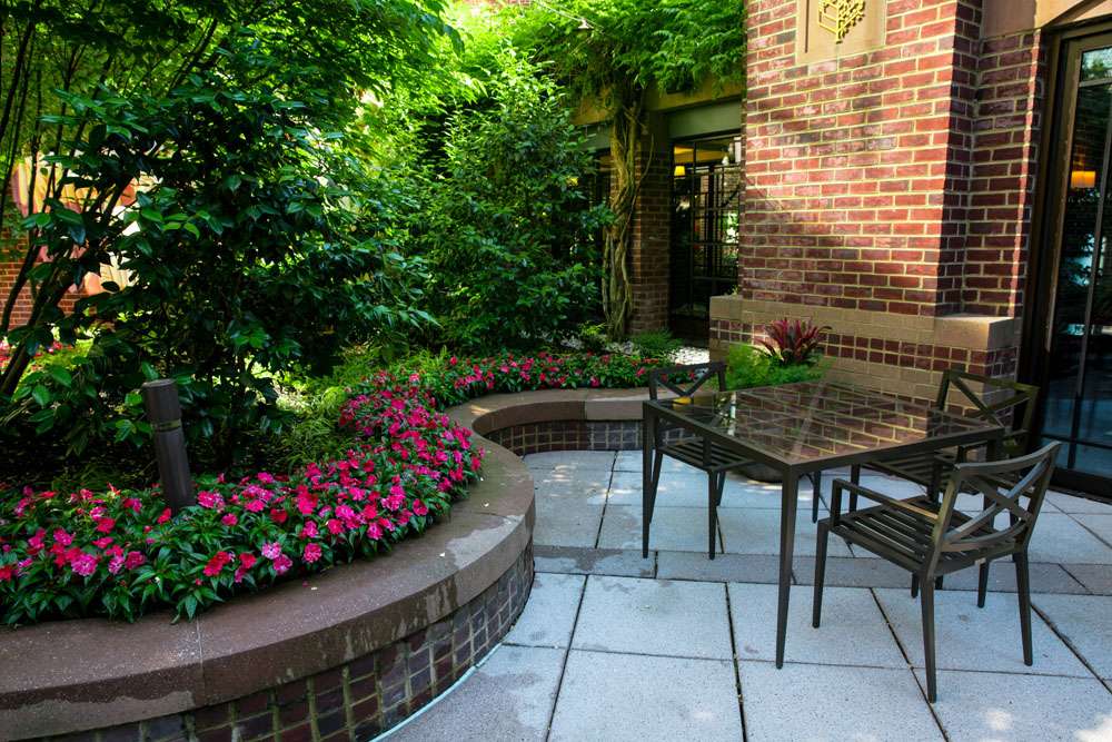 Paver patio with a table, chairs and planted borders