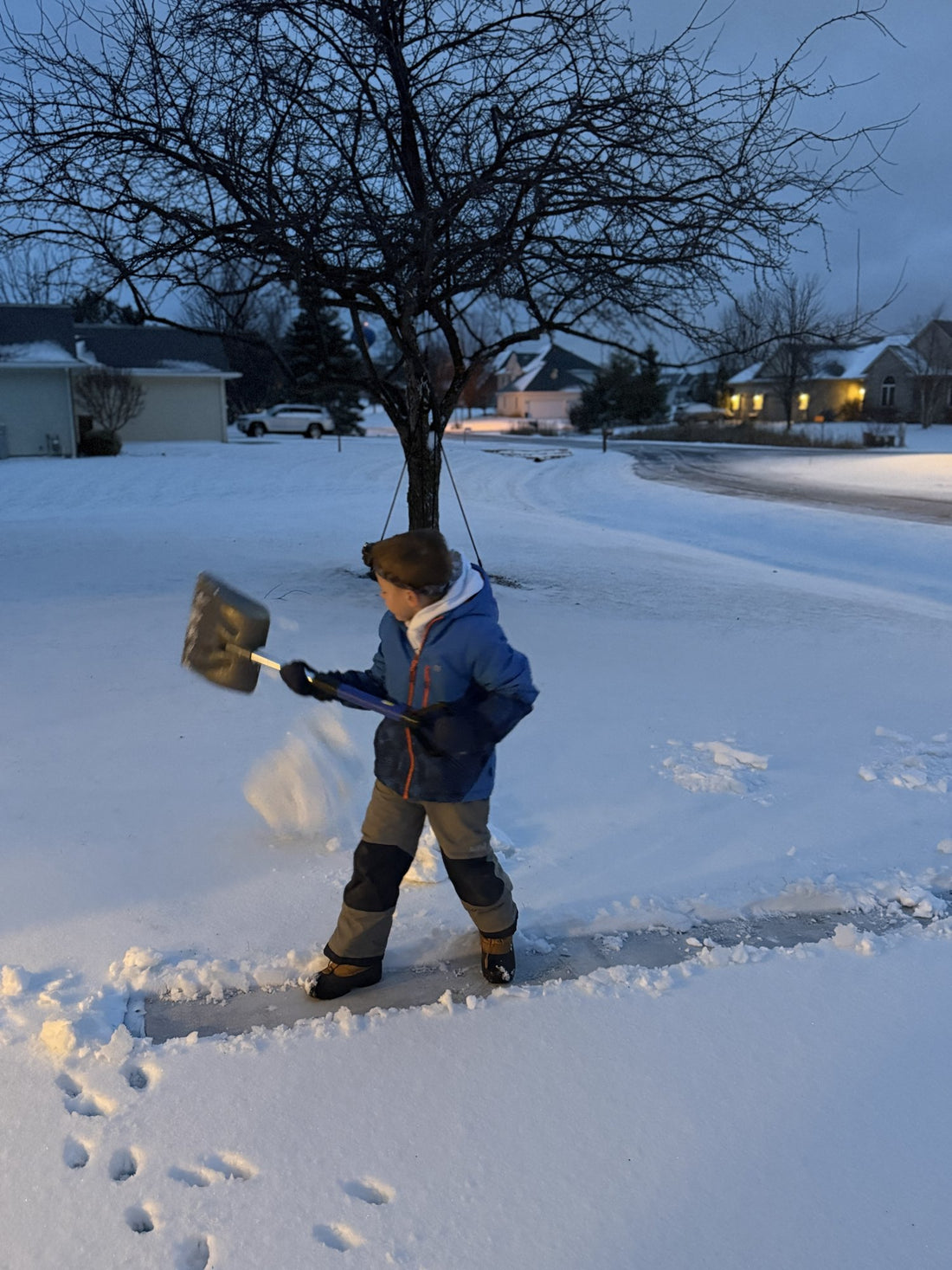Mack, six years old, shoveling a neighbor's driveway at dusk the winter before Sunny Stripes started