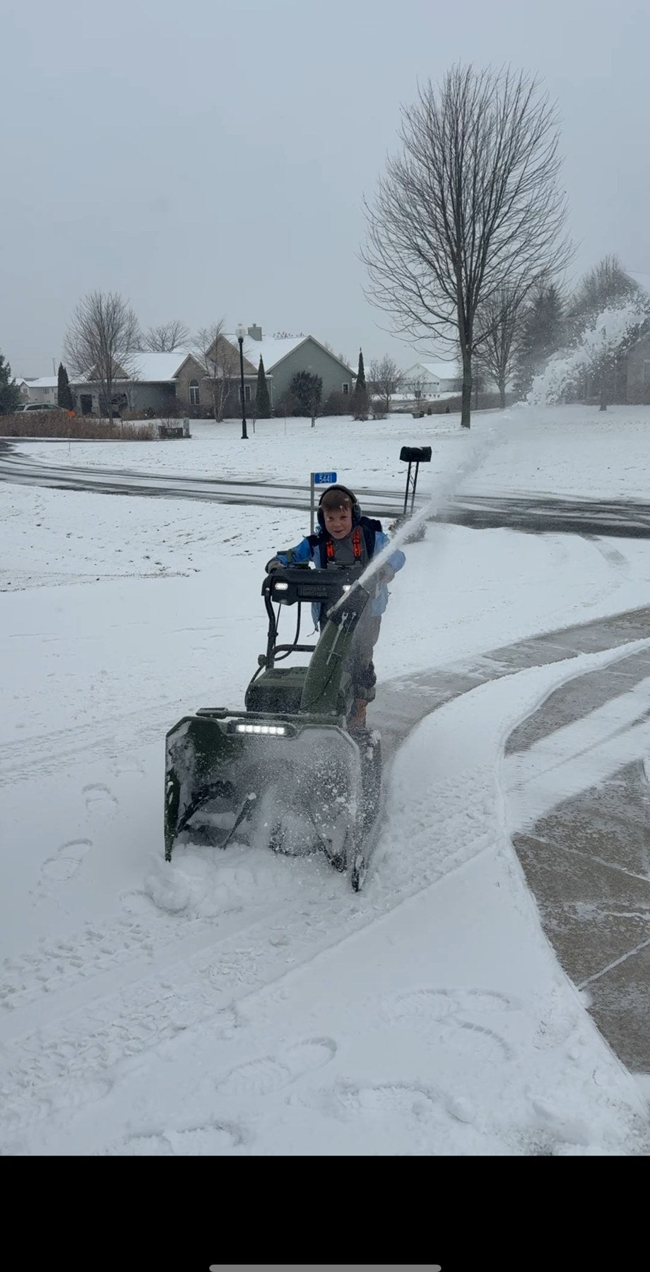 Mack clearing a driveway with a snowblower
