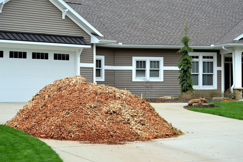 Load of bulk mulch dumped on a driveway